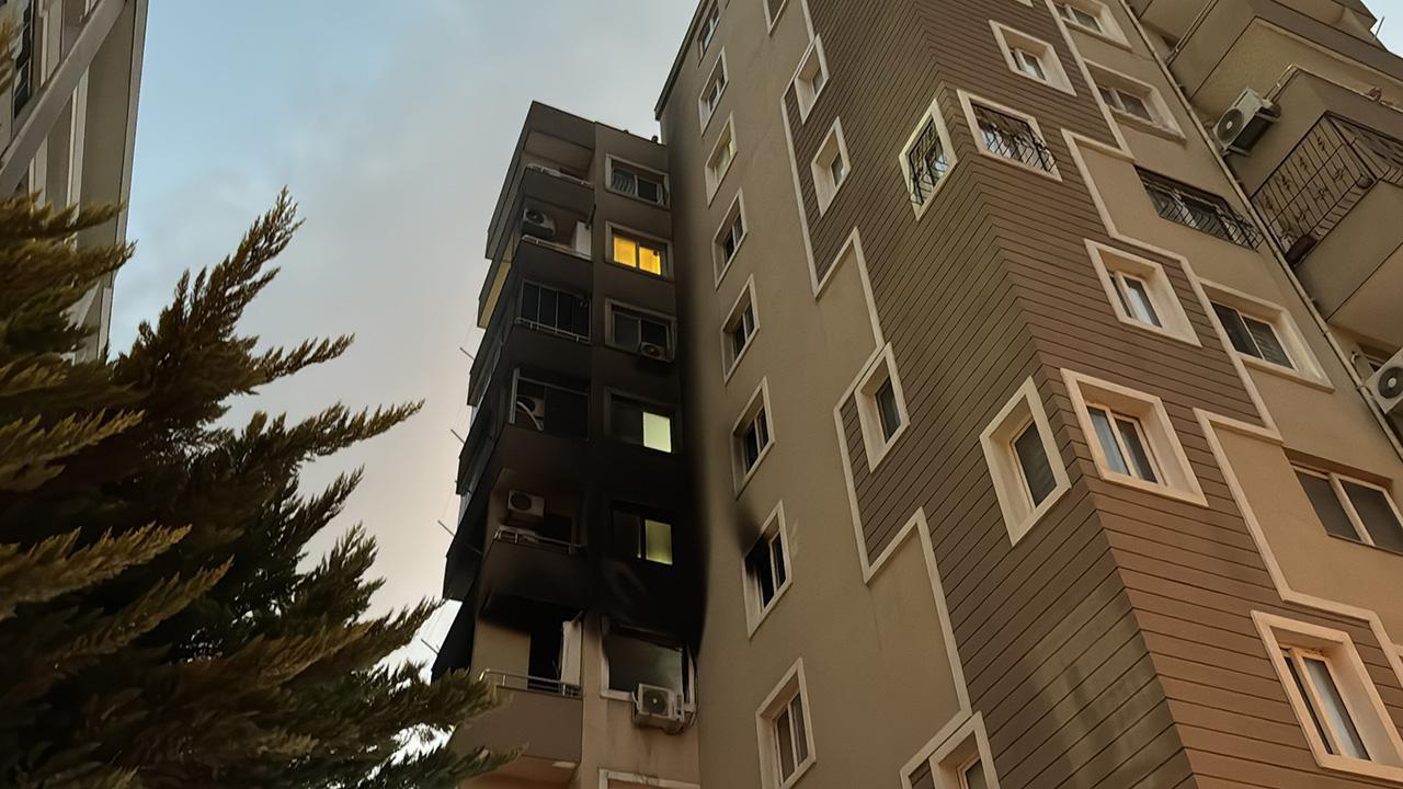 Adana'da 9 katlı apartmanda çıkan yangında, 4. kattaki dairenin penceresinden